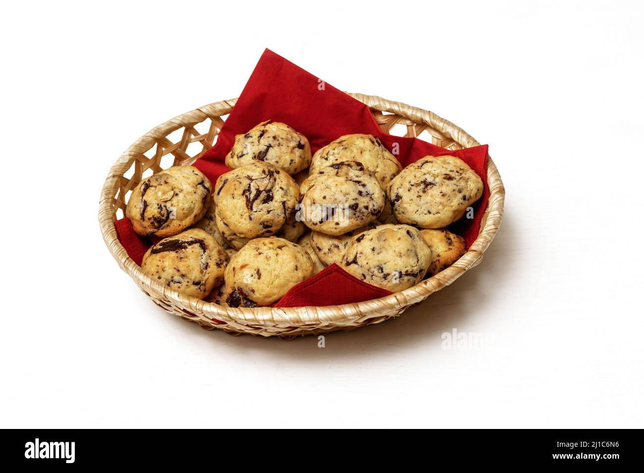 Basket on a white background with a red napkin and delicious homemade cookies stuffed with nuts and chocolate pieces. Stock Photo