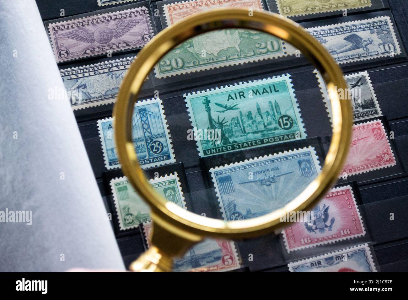 Moscow, Russia, March 2022: Hobbies: collecting and exploring postage stamps. An album with old stamps. Looking at the green stamp with Statue of Libe Stock Photo