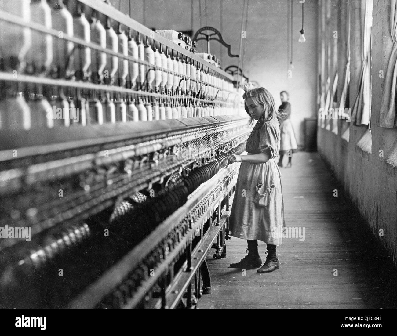 Sadie Pfeiffer, Spinner in Cotton Mill, North Carolina by Lewis Hine (1874-1940), 1908. The photograph shows a young girl working in a cotton mill as child labor Stock Photo