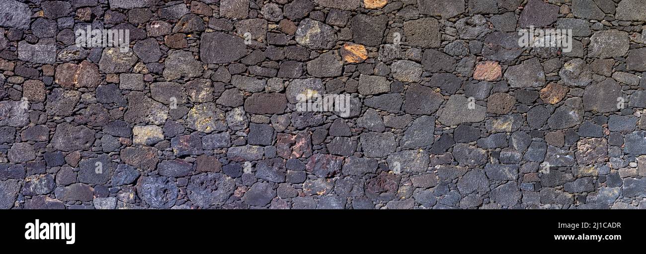 Panoramic stone wall made of volcanic rock Stock Photo