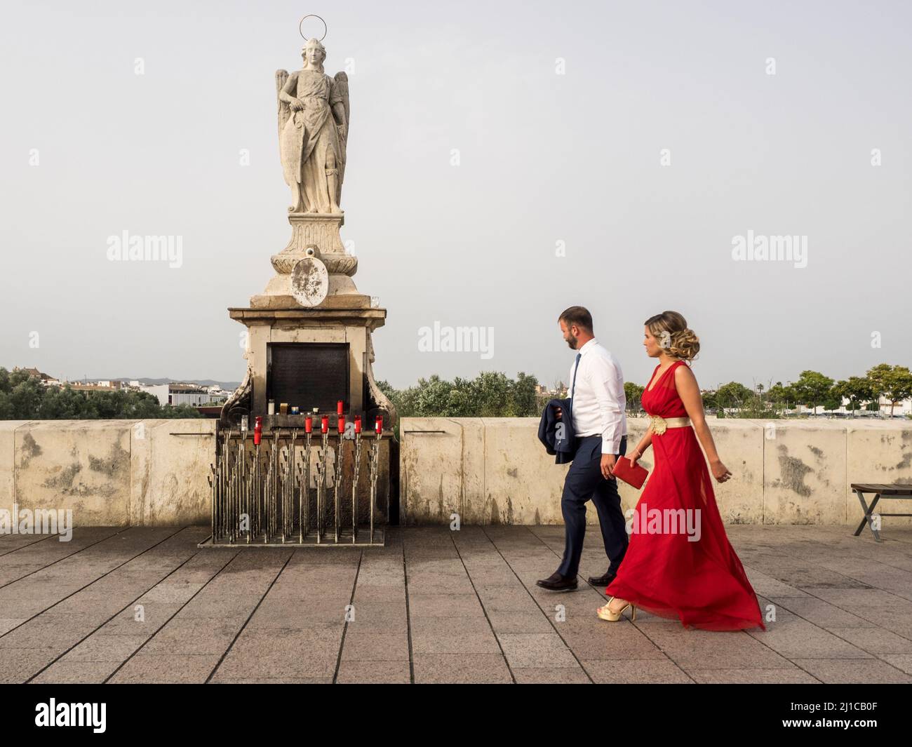 Young heterosexual couple walking on the roman bridge of Cordoba Stock Photo