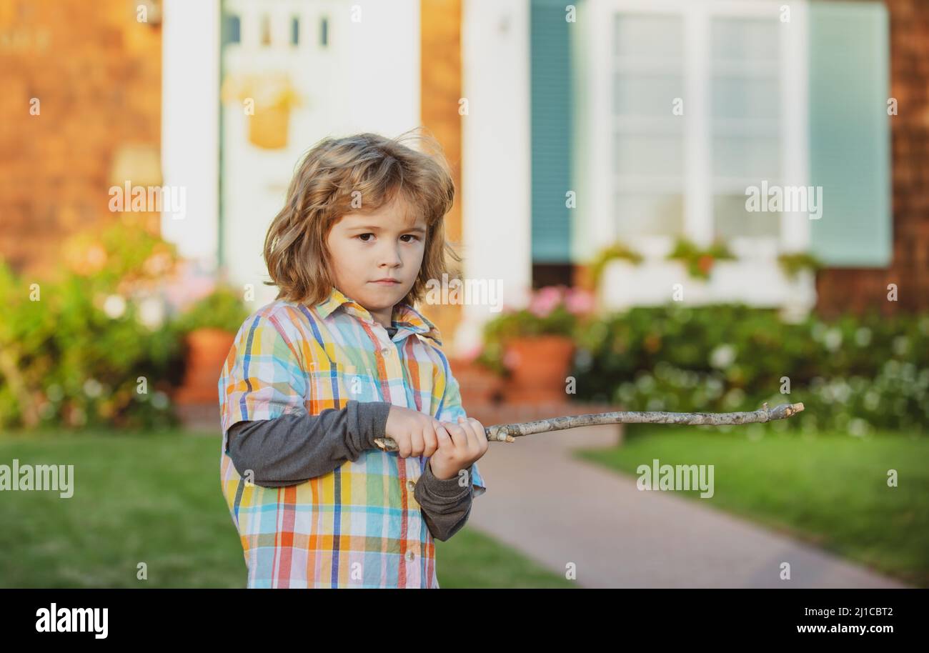Kids aggression. Negative child emotion. Angry boy with stick. Kid
