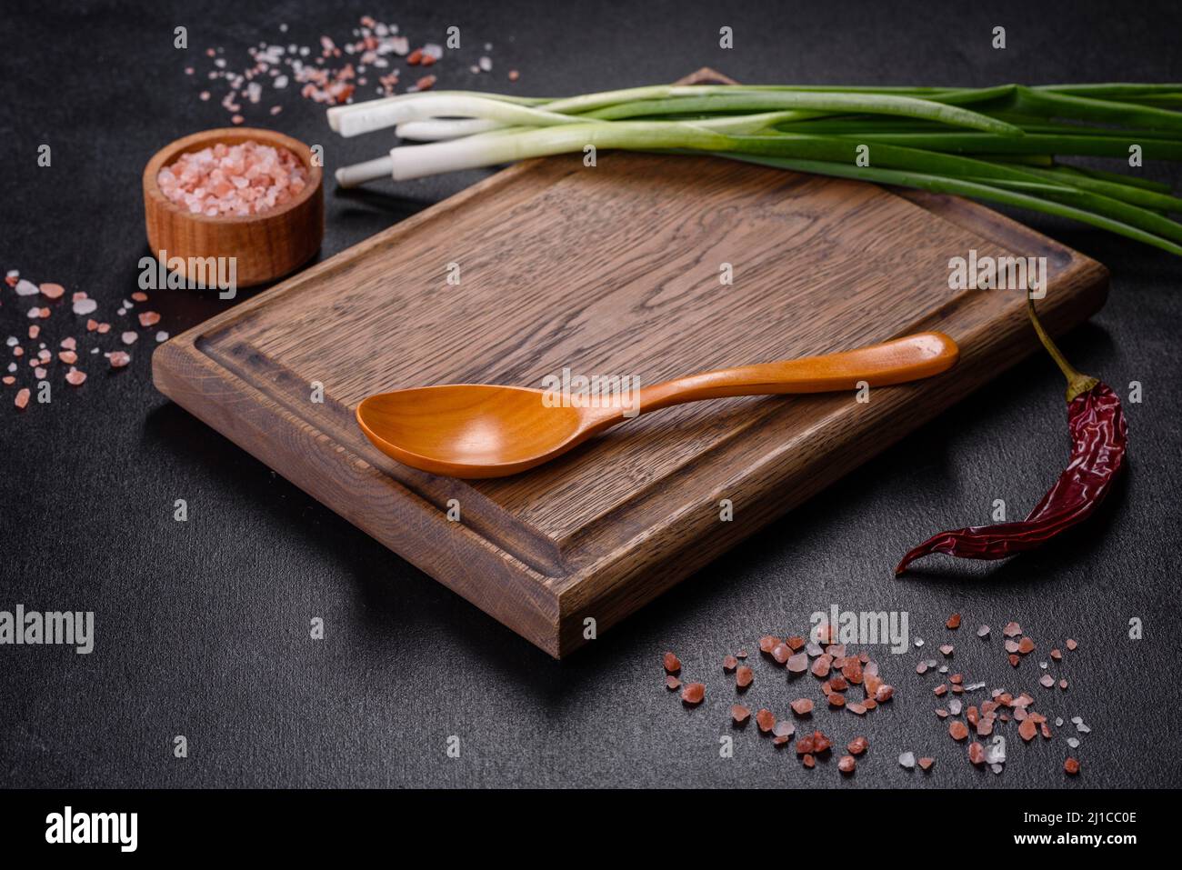 Cut Green onions chives on a cutting board. Dark wooden background ...