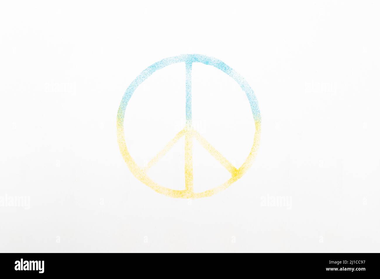 Real airbrush in blue and yellow shows the national colors of Ukraine. With a homemade stencil in the shape of the peace sign, the white paper was lef Stock Photo