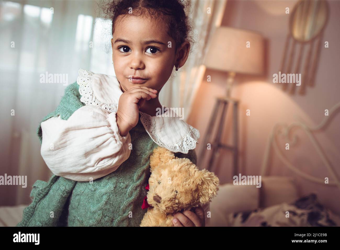 Adorable multiethnic little girl holding her teddy bear Stock Photo
