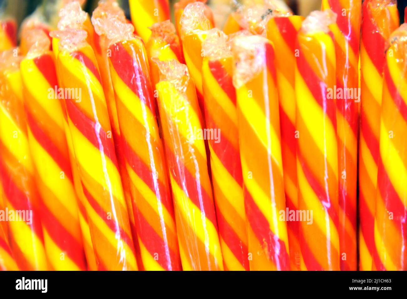 Background image shows yellow and orange candy sticks. They are