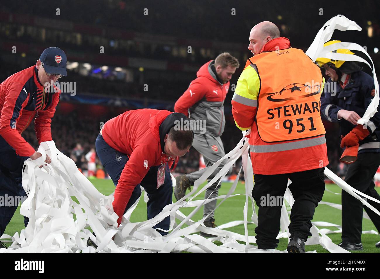 LONDON, ENGLAND - MARCH 7, 2017: Stewards clean the pitch after Bayern ultras thrown paper rolls during the second leg of the UEFA Champions League Round of 16 game between Arsenal FC and Bayern Munchen at Emirates Stadium. Copyright: Cosmin Iftode/Picstaff Stock Photo