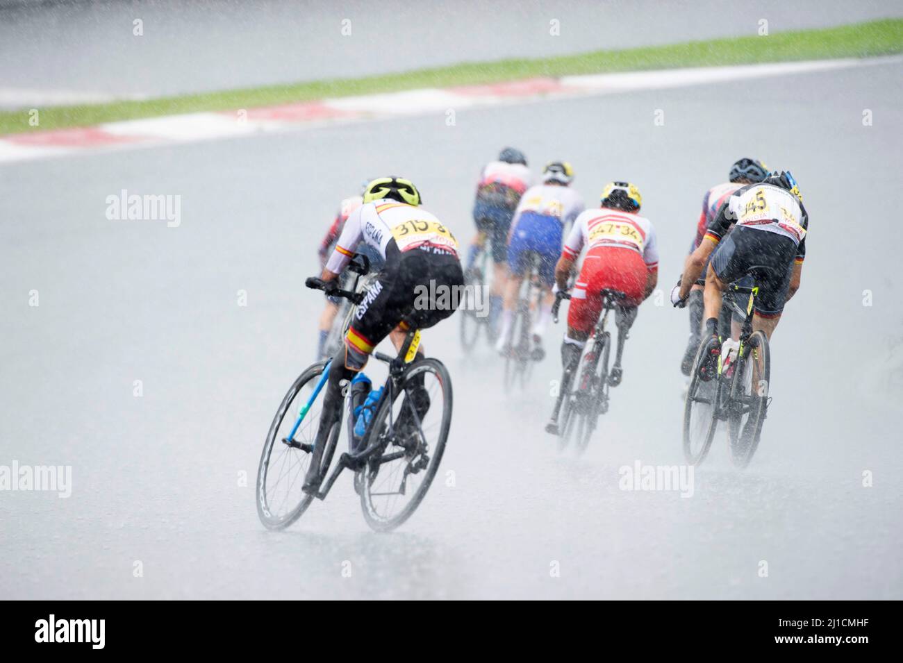 Richard Argiles of Spain follows the peloton around a slippery corner during a heavy rain in the men's paracycling road race, Tokyo 2020 Paralympics. Stock Photo