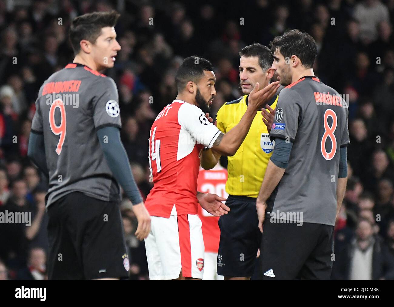 LONDON, ENGLAND - MARCH 7, 2017: Theo Walcott (L) of Arsenal and Javi Martinez (R) of Bayern argue in front of Greek FIFA referee Tasos Sidiropoulos during the second leg of the UEFA Champions League Round of 16 game between Arsenal FC and Bayern Munchen at Emirates Stadium.  Copyright: Cosmin Iftode/Picstaff Stock Photo