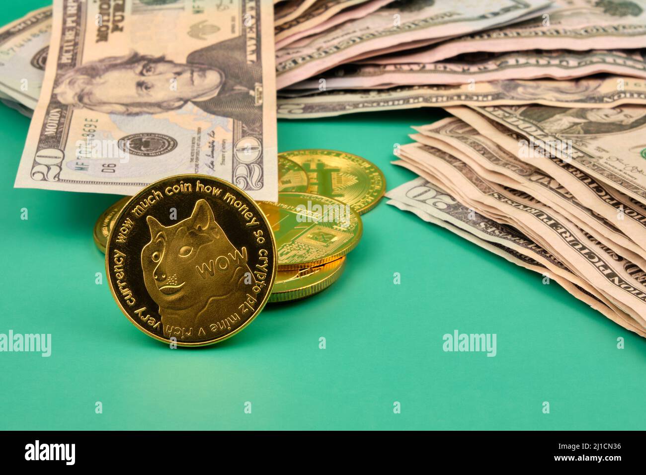 A pile of dollars and a few dogecoin on a green table. Photograph in  vertical format. Copy space Stock Photo - Alamy