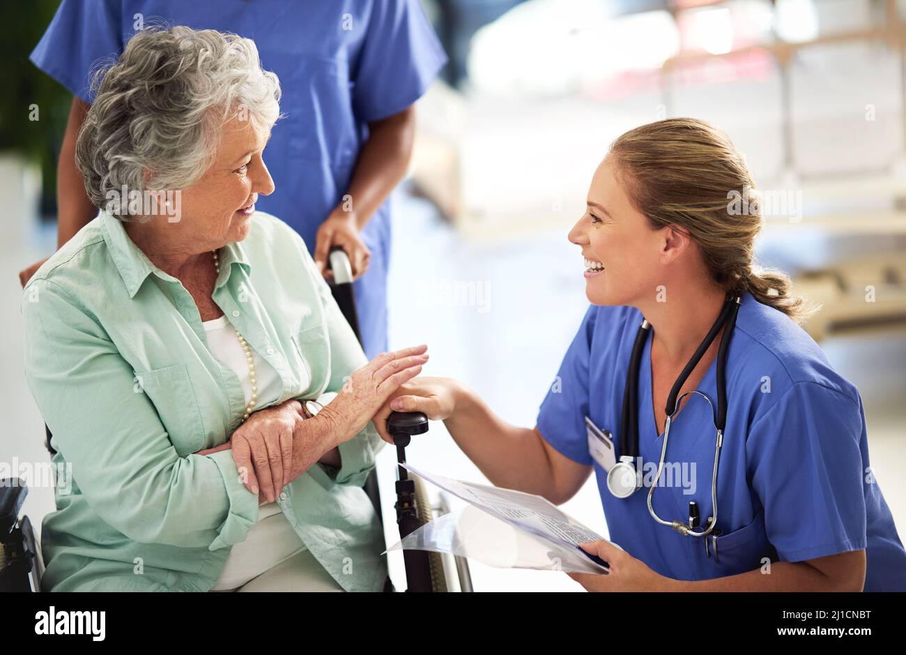 Ive got some good news for you. Shot of a doctor discussing treatments with a senior woman sitting in wheelchair in a hospital. Stock Photo