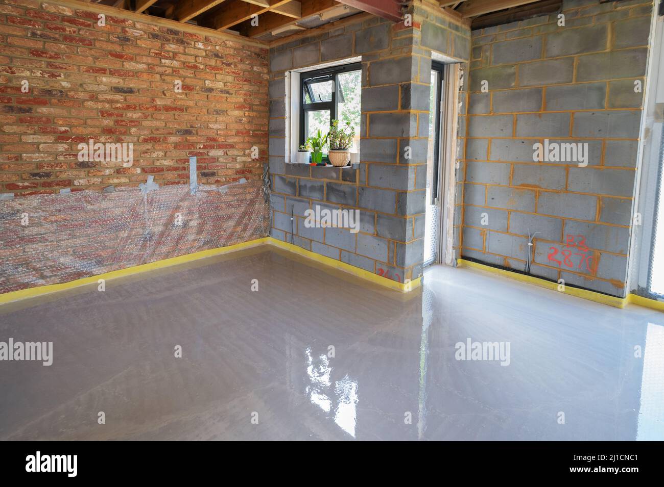 Screeding over underfloor heating pipes in residential property Stock