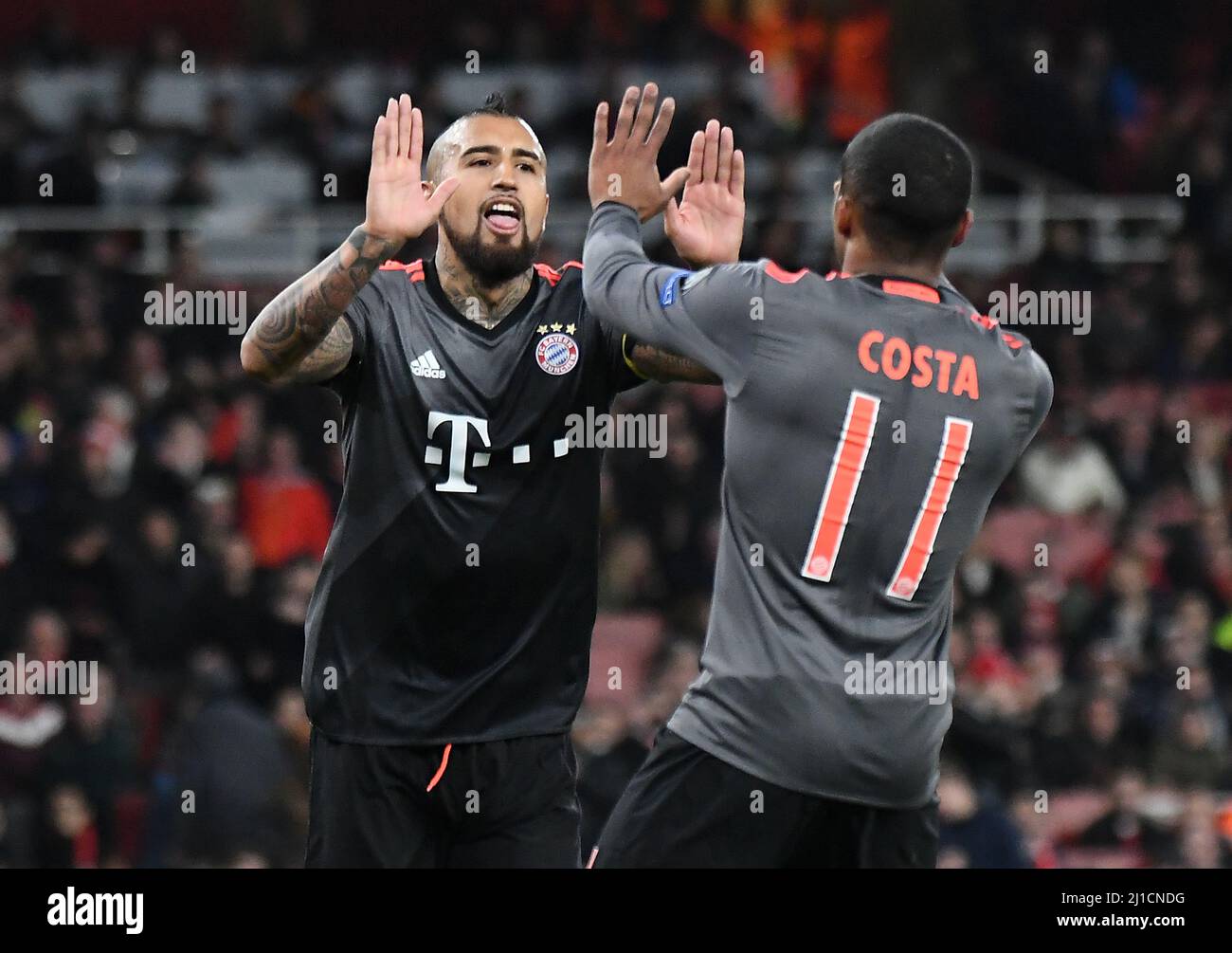 LONDON, ENGLAND - MARCH 7, 2017: Arturo Vidal of Bayern congratulated by Douglas Costa (R) after he scored a goal during the second leg of the UEFA Champions League Round of 16 game between Arsenal FC and Bayern Munchen at Emirates Stadium. Copyright: Cosmin Iftode/Picstaff Stock Photo