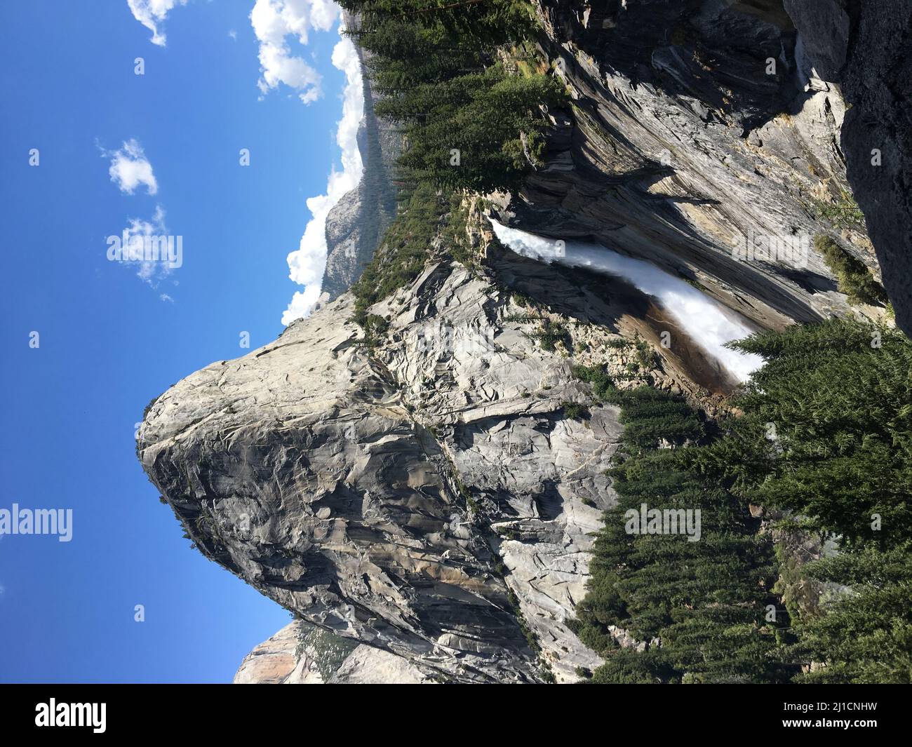 Outside Rocy A vertical shot of a rocky mountain with a waterfall Stock Photo - Alamy