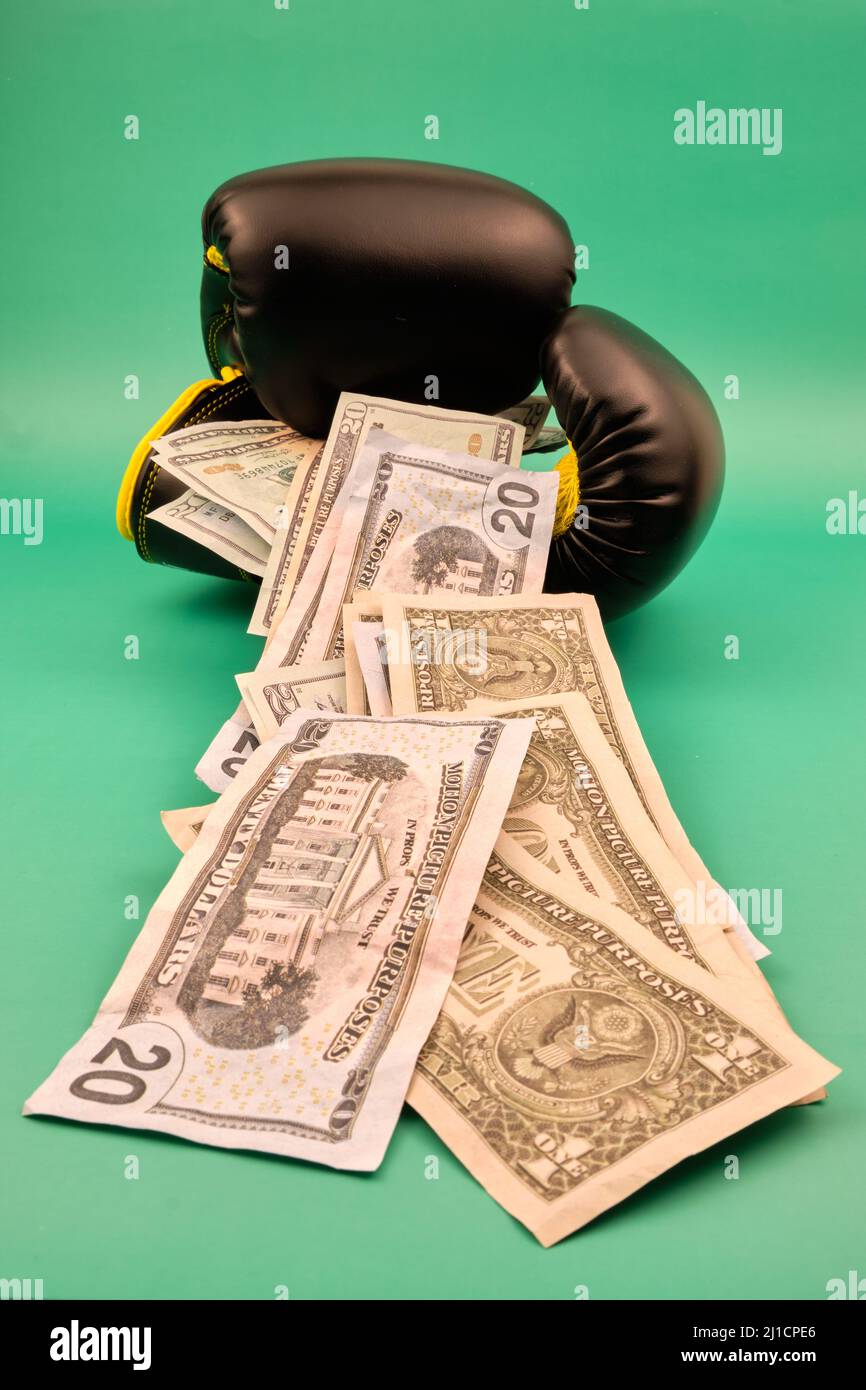 boxing gloves with a lot of dollars on a green background Stock Photo