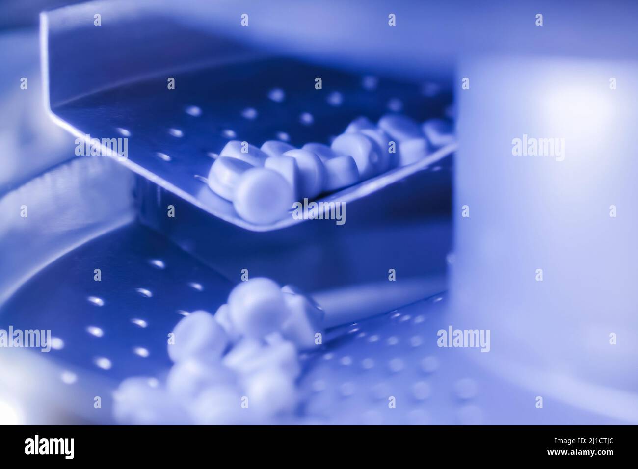 Close up: deduster machine with conveyor for dedusting pills, tablets, meds Stock Photo