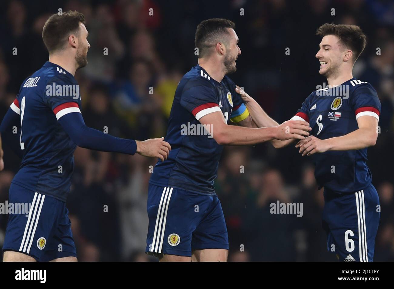 Glasgow, Scotland, 24th March 2022.  Stephen O'Donnell and John McGinn celebrate with goal scorer Kieran Tierney of Scotland during the International Friendly match at Hampden Park, Glasgow. Picture credit should read: Neil Hanna / Sportimage Stock Photo