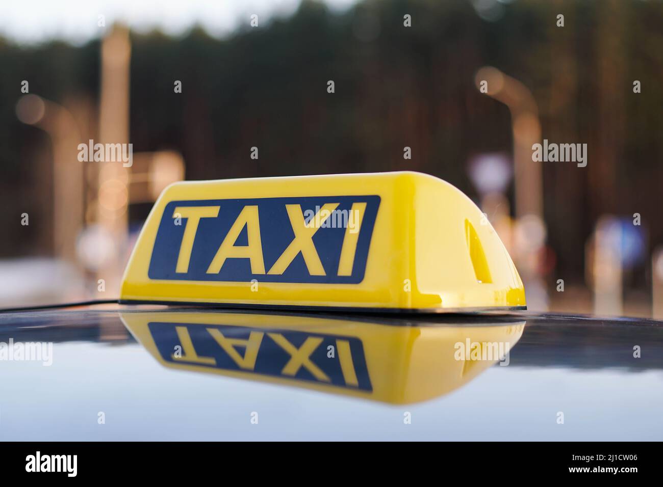 Close Up Of Taxi Cab Sign On a Car Roof. Daytime Traffic On The