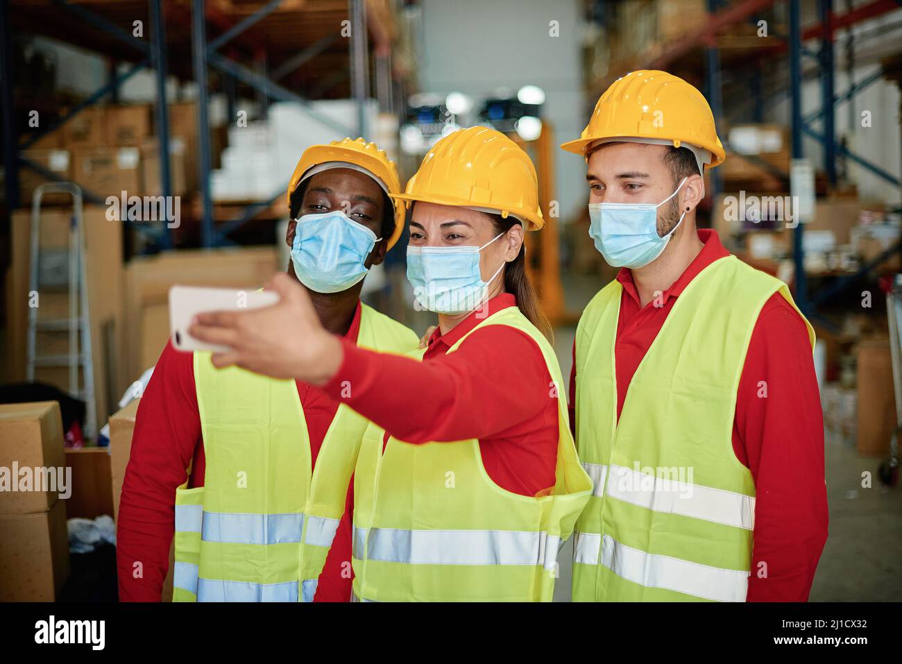 Happy multiracial workers taking a selfie inside the warehouse safety