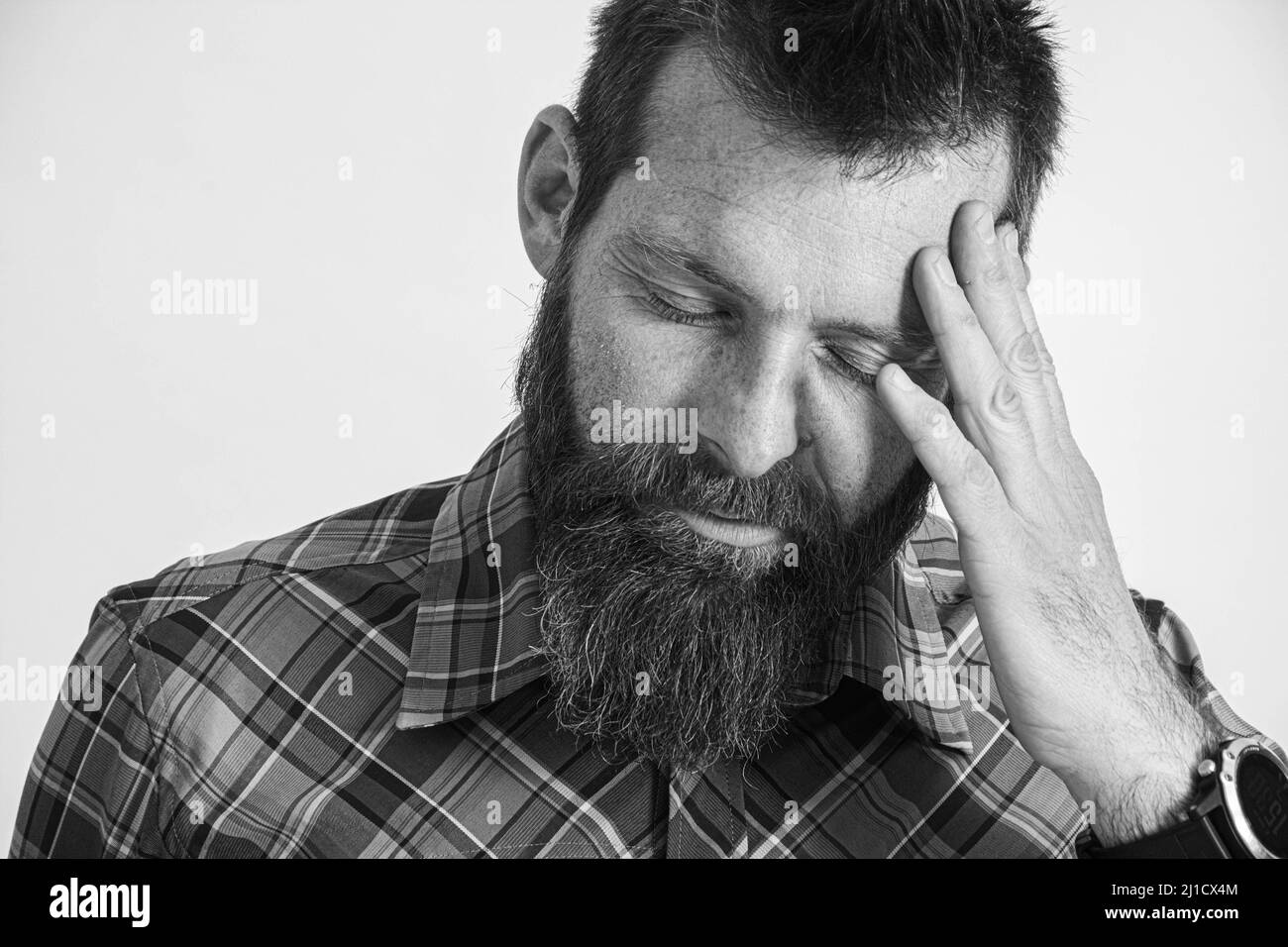 Upset man standing with his hand holding his forehead Stock Photo