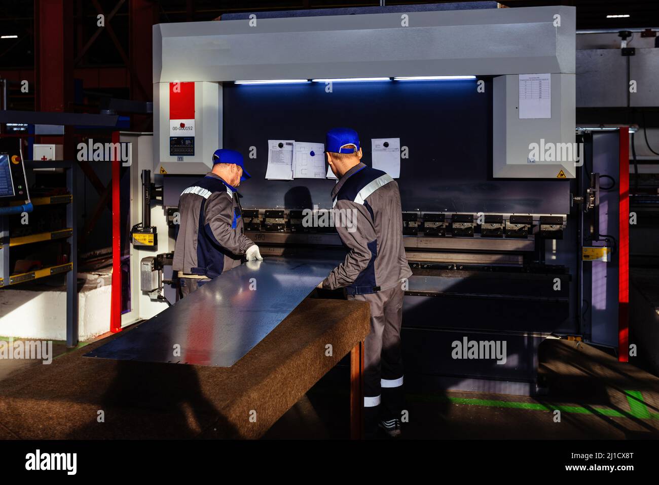 Technician operators working with with sheet metal on CNC hydraulic