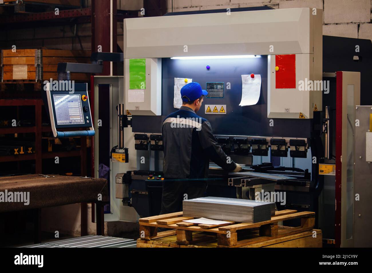 Technician operator working with with sheet metal on CNC hydraulic