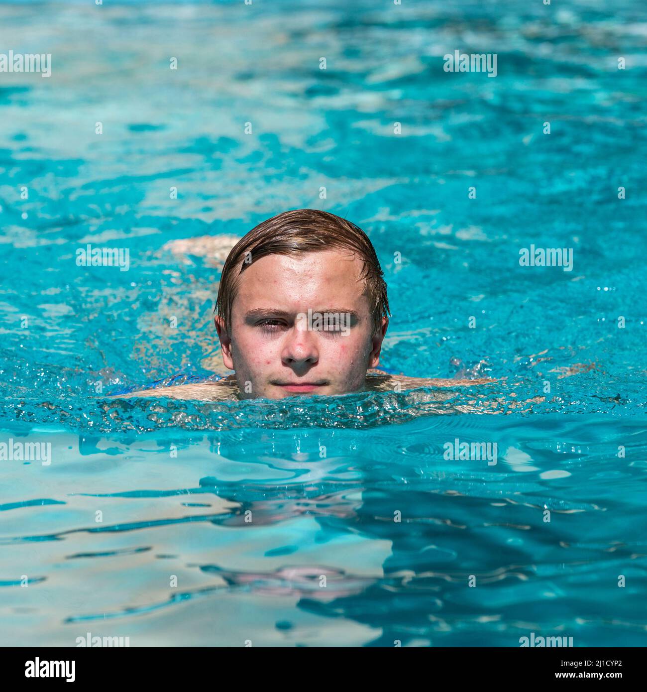 boy enjoys swimming in the outdoor swimming pool Stock Photo Alamy