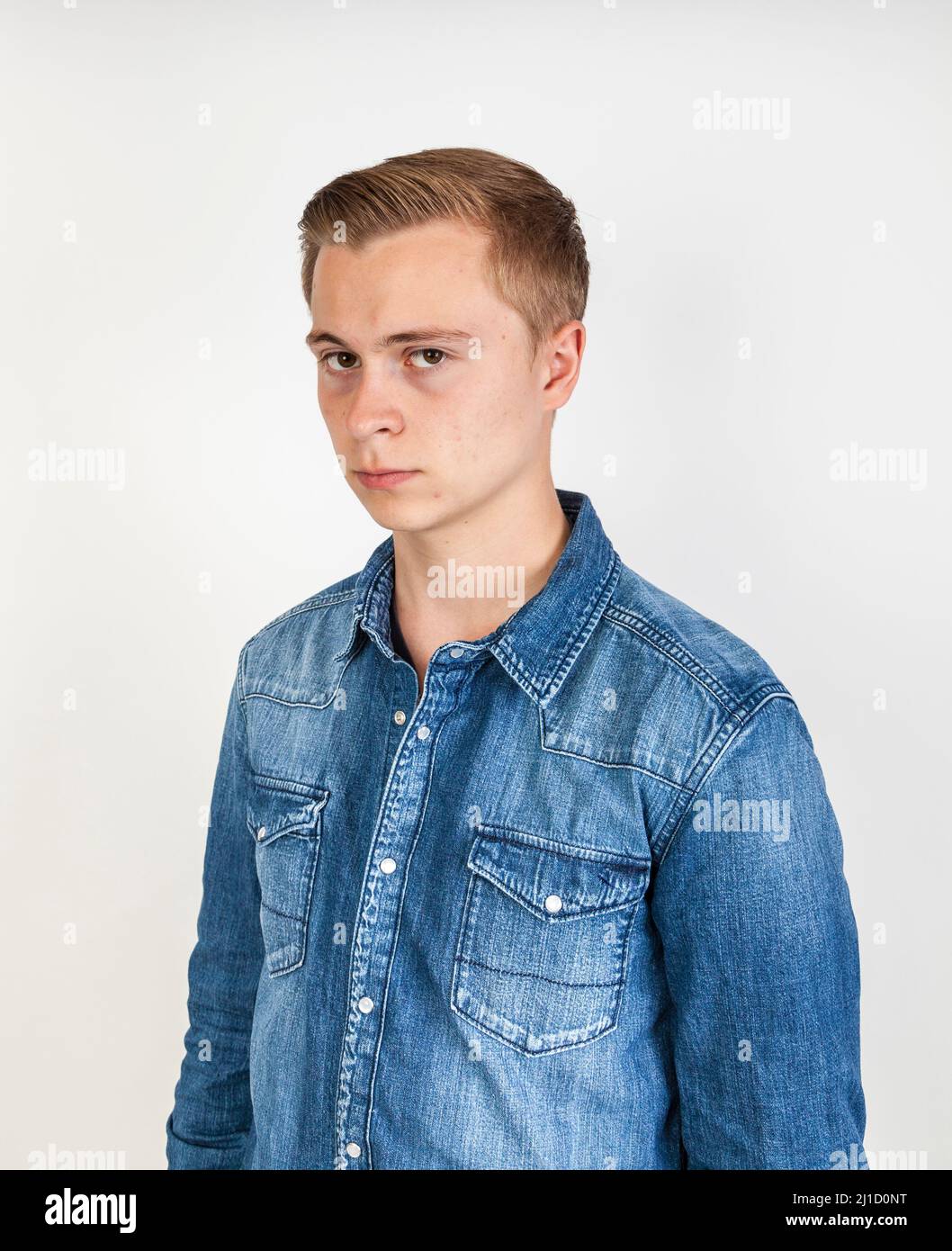 portrait of angry looking boy posing in studio Stock Photo Alamy
