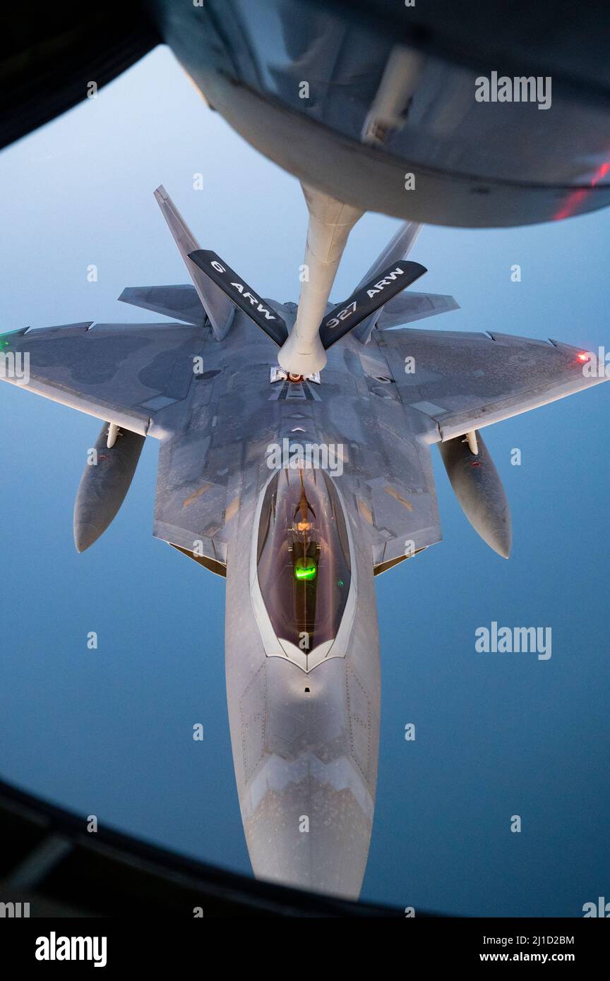 A U.S. Air Force F-22 Raptor receives fuel from a U.S. Air Force KC-135 Stratotanker assigned to the 340th Expeditionary Air Refueling Squadron, above the U.S. Central Command area of responsibility, March 14, 2022. The F-22 Raptor is a fifth-generation aircraft that combines stealth, supercruise, maneuverability, integrated avionics, and is designed to project air dominance, rapidly and at great distances, and deter regional aggressors while deployed in the USCENTCOM AOR. (U.S. Air Force photo by Staff Sgt. Frank Rohrig) Stock Photo