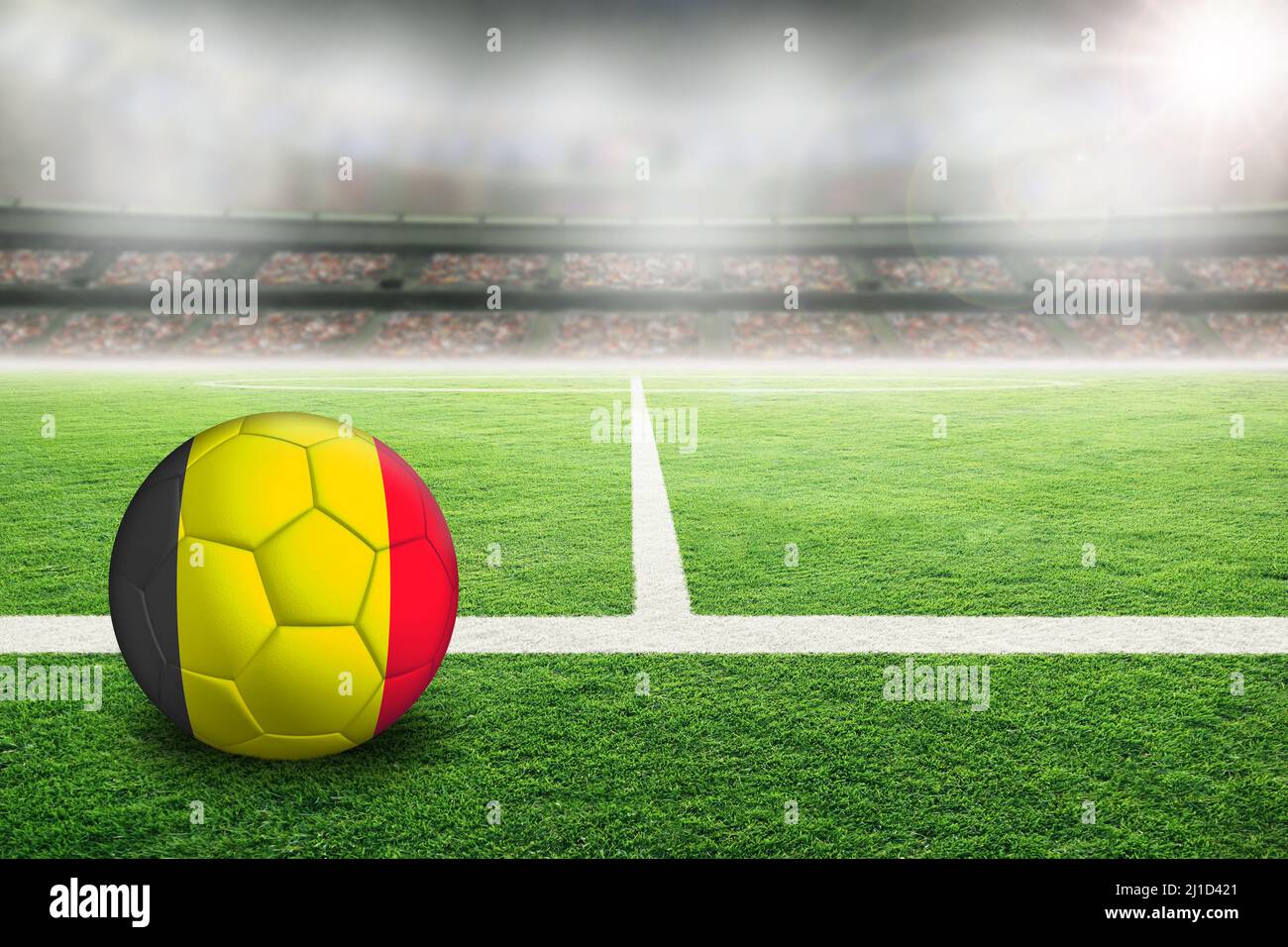 Football in brightly lit outdoor stadium with painted flag of Belgium. Focus on foreground and soccer ball with shallow depth of field on background a Stock Photo