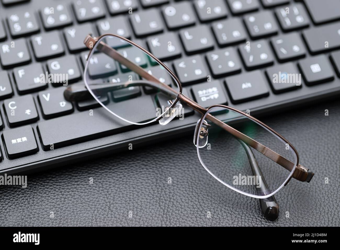 Stylish eyesight glasses with computer keyboard. Alphabetics and Japanese hiragana typing keyboard. Stock Photo