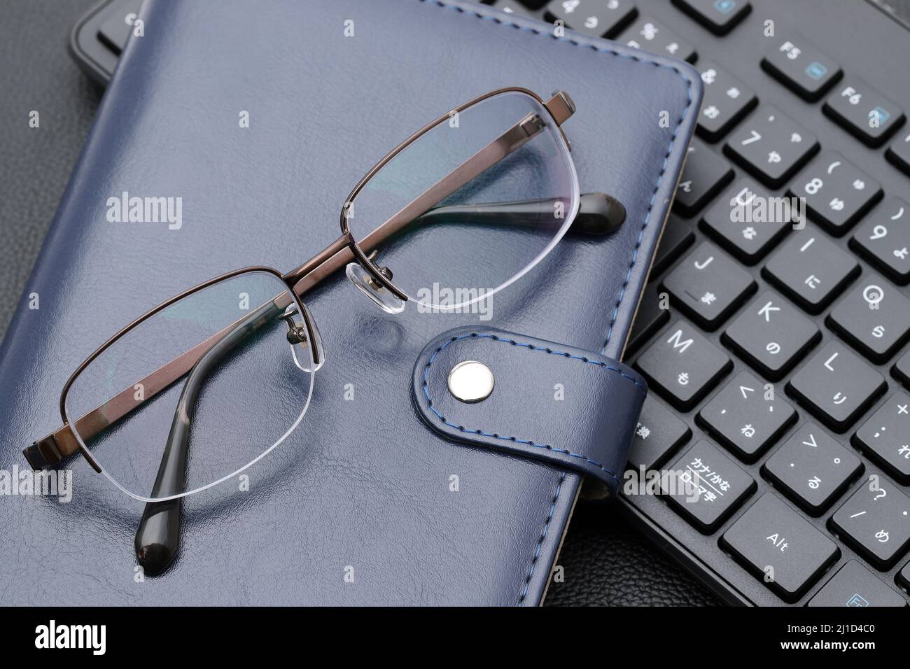 Eyesight glasses with note book, computer keyboard. Alphabetics and
