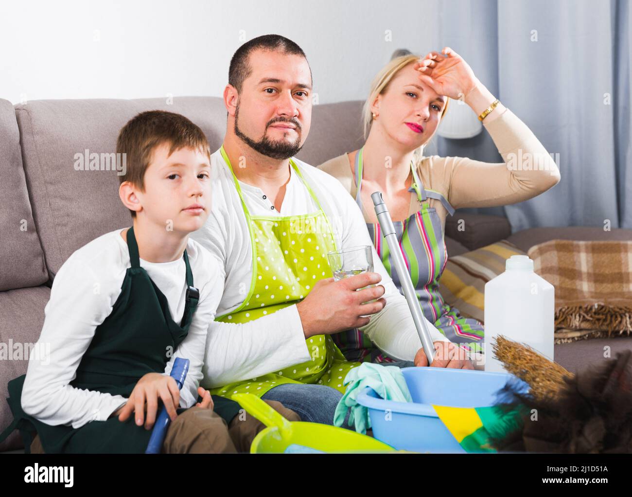 Tired parents with son dressed for cleaning Stock Photo - Alamy