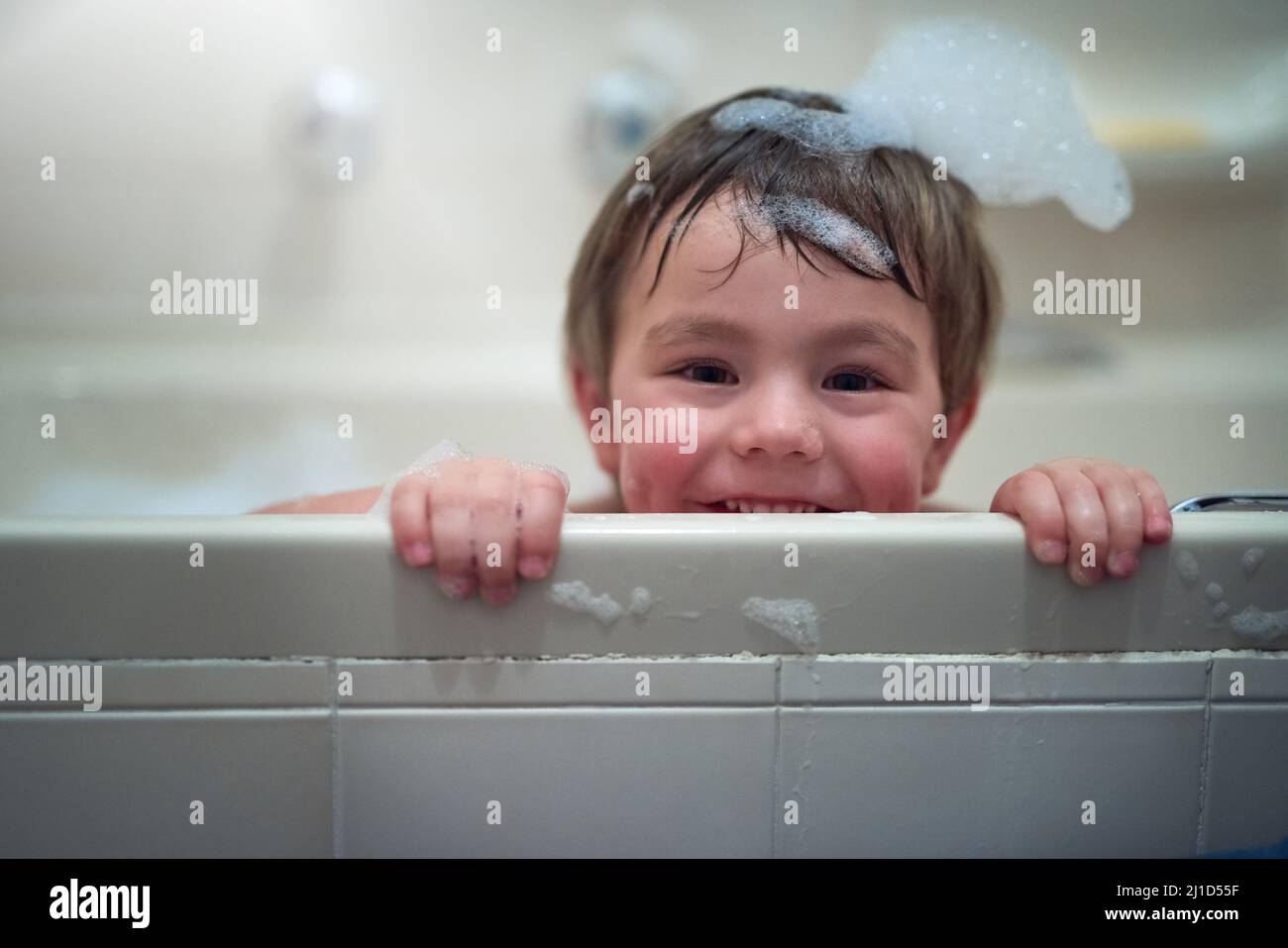 What is bath time without the bubbles. Portrait of a little boy sitting