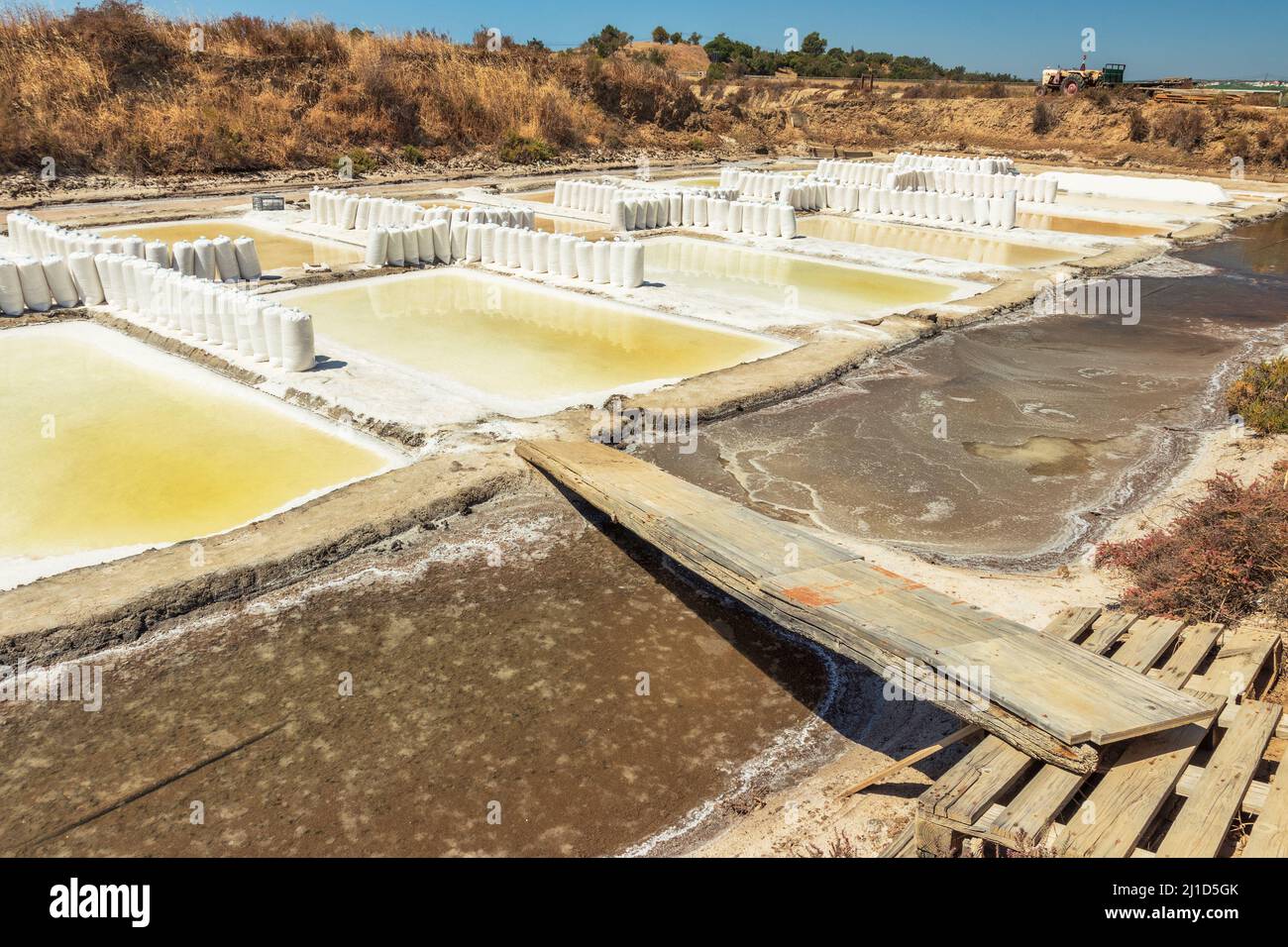 View of the Castro Marim salt pans in the Algarve, Portugal, with bags full of salt in the middle of a sunny day. Stock Photo