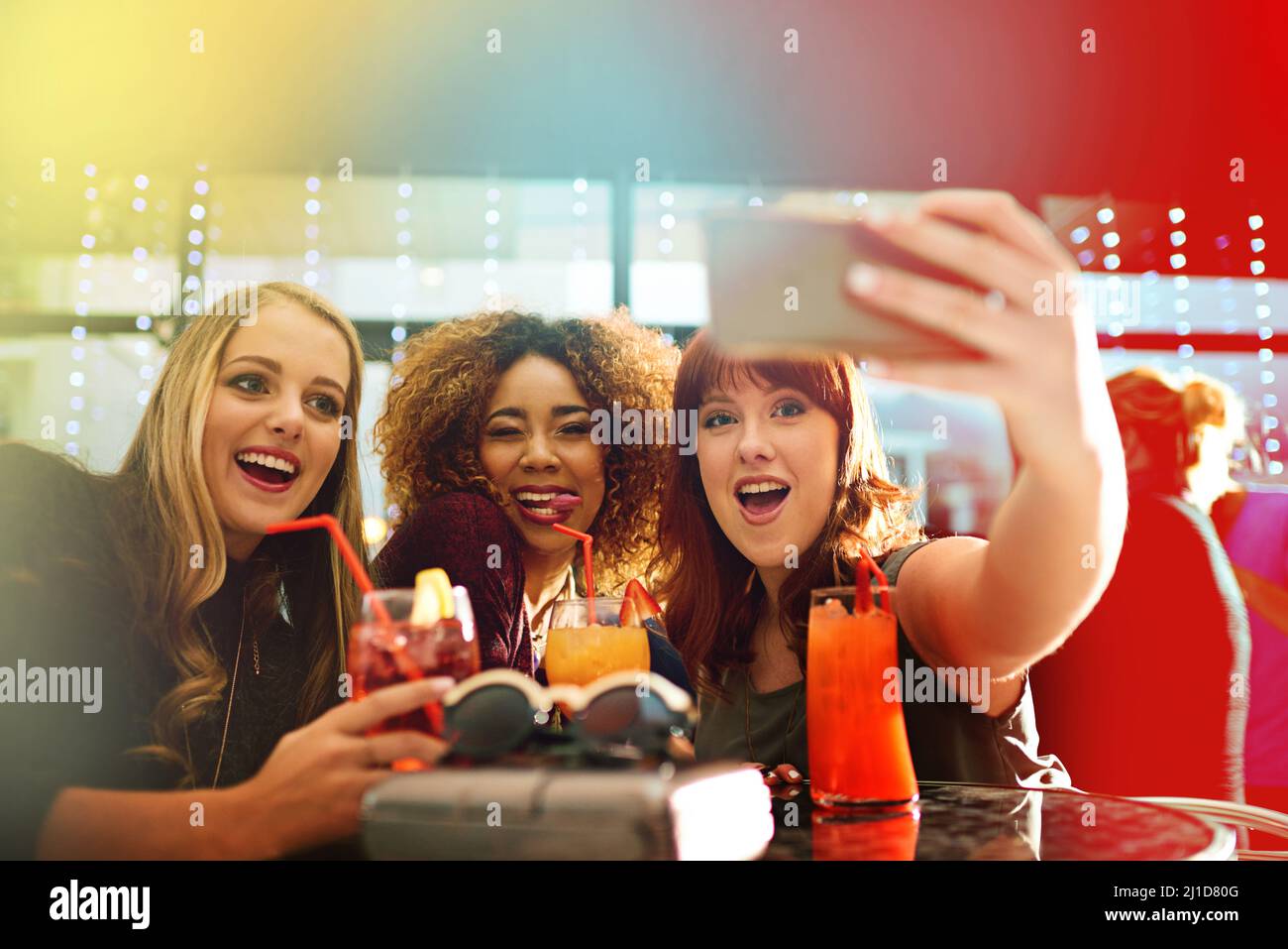 Memorable moments from the party. Shot of young friends taking selfies while having drinks at a party. Stock Photo
