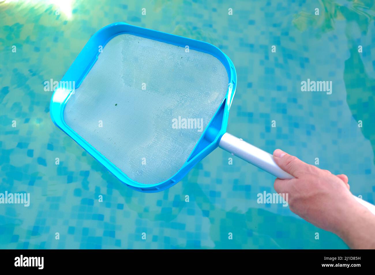 Swimming Pool for cleaning the pool in hands on blue water