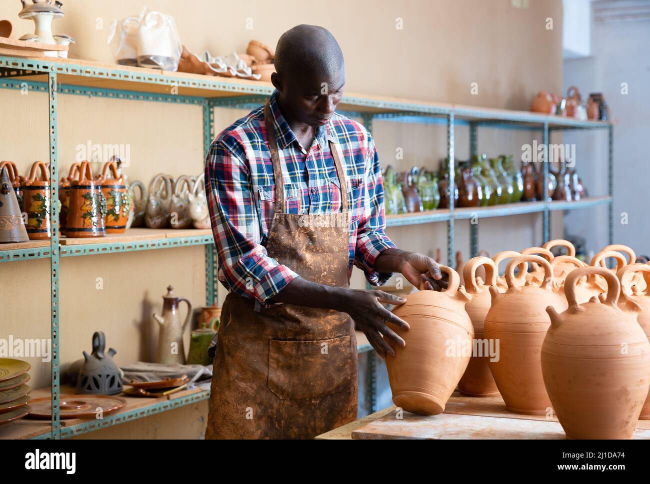 Africanamerican artisan in apron having ceramics in store warehouse Stock Photo Alamy