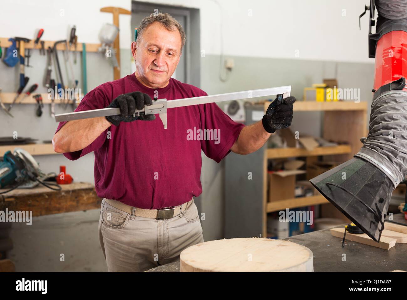 Worker Using Calipers Worker performs measurements on wooden workpiece with caliper Stock ...