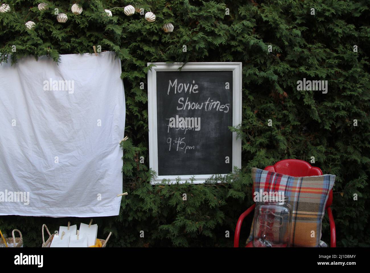 White sheet ready for a movie night outdoors with food and chairs Stock Photo