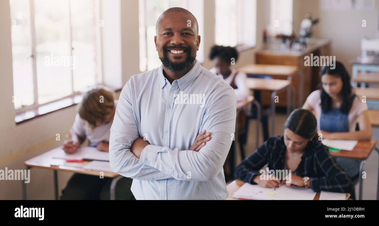 Welcome to our world of learning. Portrait of mature man teaching a class of teenage students. Stock Photo