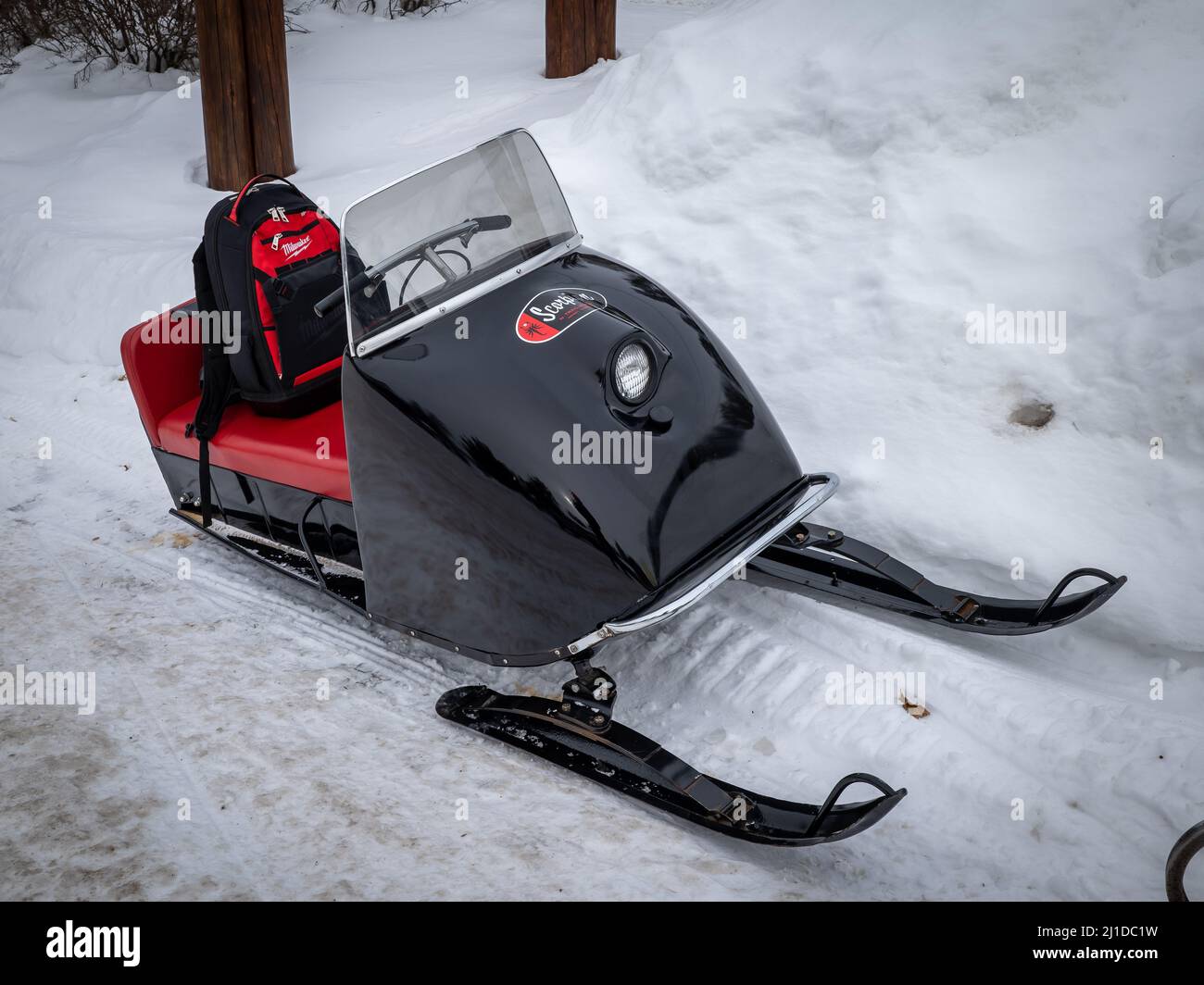 NISSWA, MN - 5 JAN 2022: Old Scorpion snowmobile sits on winter snow. Black 1970s vintage sled with red seat. Stock Photo
