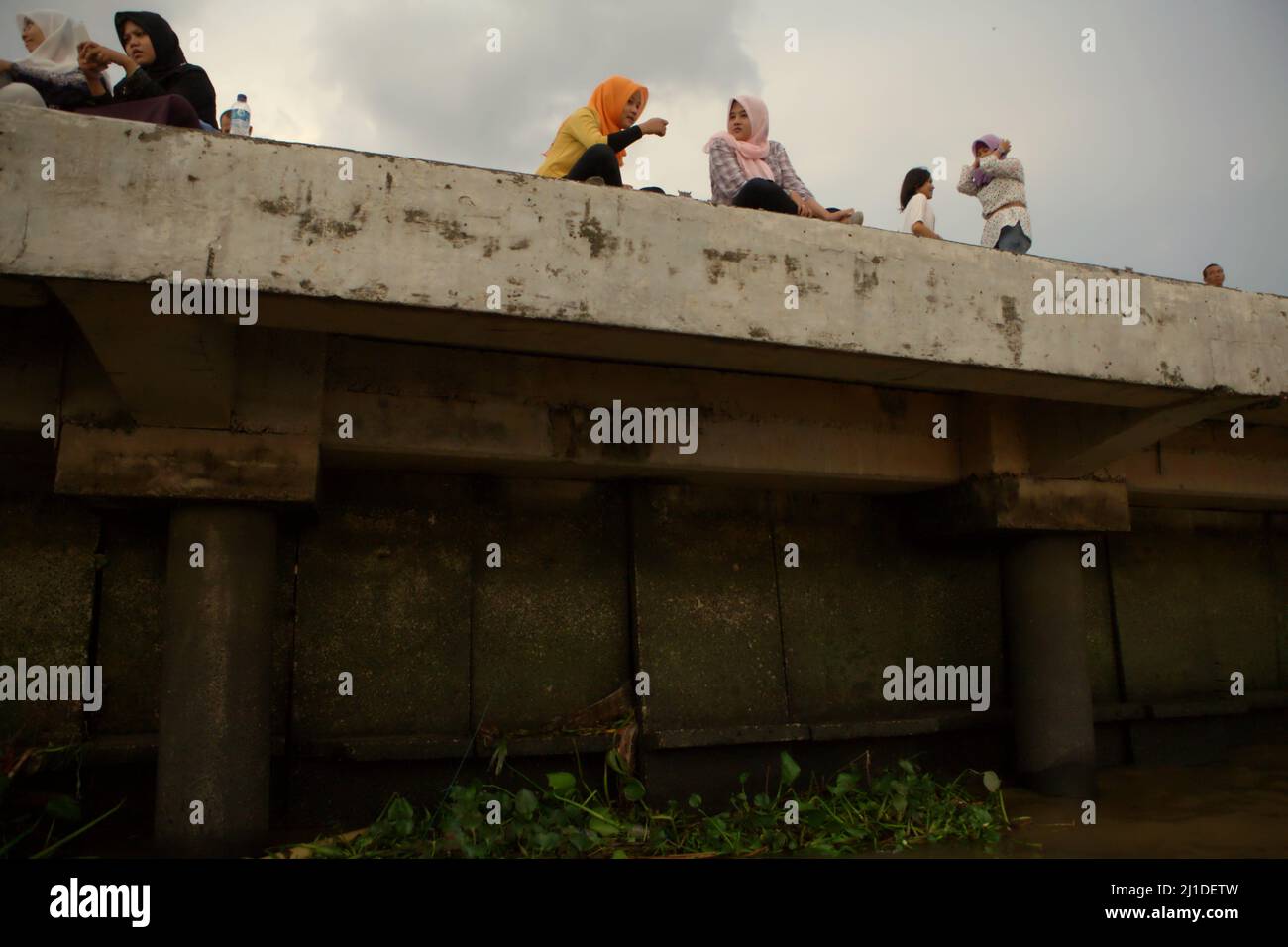 Teenagers having a leisure time on the side of Musi river in Palembang, South Sumatra, Indonesia. Credits: REY Pictures/Alamy Stock Photo