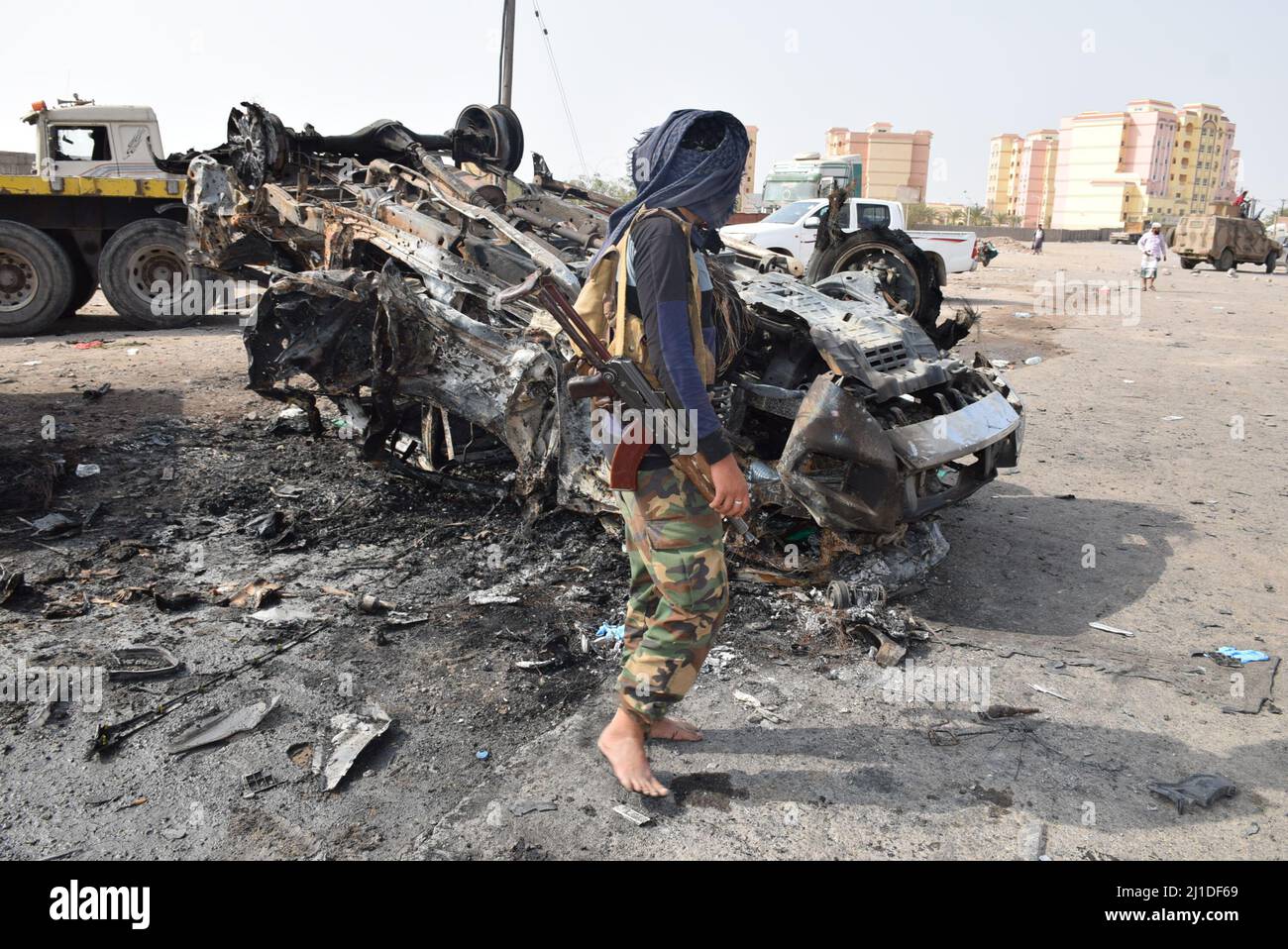 Aden, Yemen. 24th Mar, 2022. A security officer stands next to the wreckage of a car on a street of Aden, the southern port city of Yemen, on March 24, 2022. A deadly booby trap bomb attack in southern Yemen's Aden killed a high-ranking military commander of the Yemeni army and three bodyguards on Wednesday, a government official told Xinhua. Credit: Murad Abdo/Xinhua/Alamy Live News Stock Photo