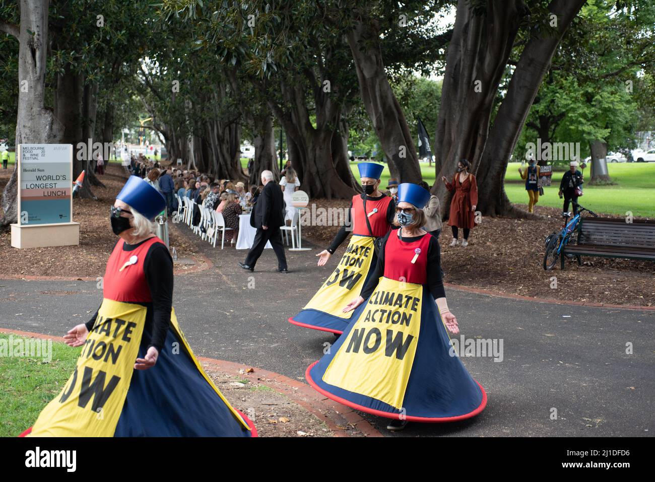 Melbourne, Australia. 25th March 2022. Extinction Rebellion protesters against climate change walk past the World's Longest Lunch taking place as part of the Melbourne Food and Wine Festival, after a school strike for climate change. Credit: Jay Kogler/Alamy Live News Stock Photo