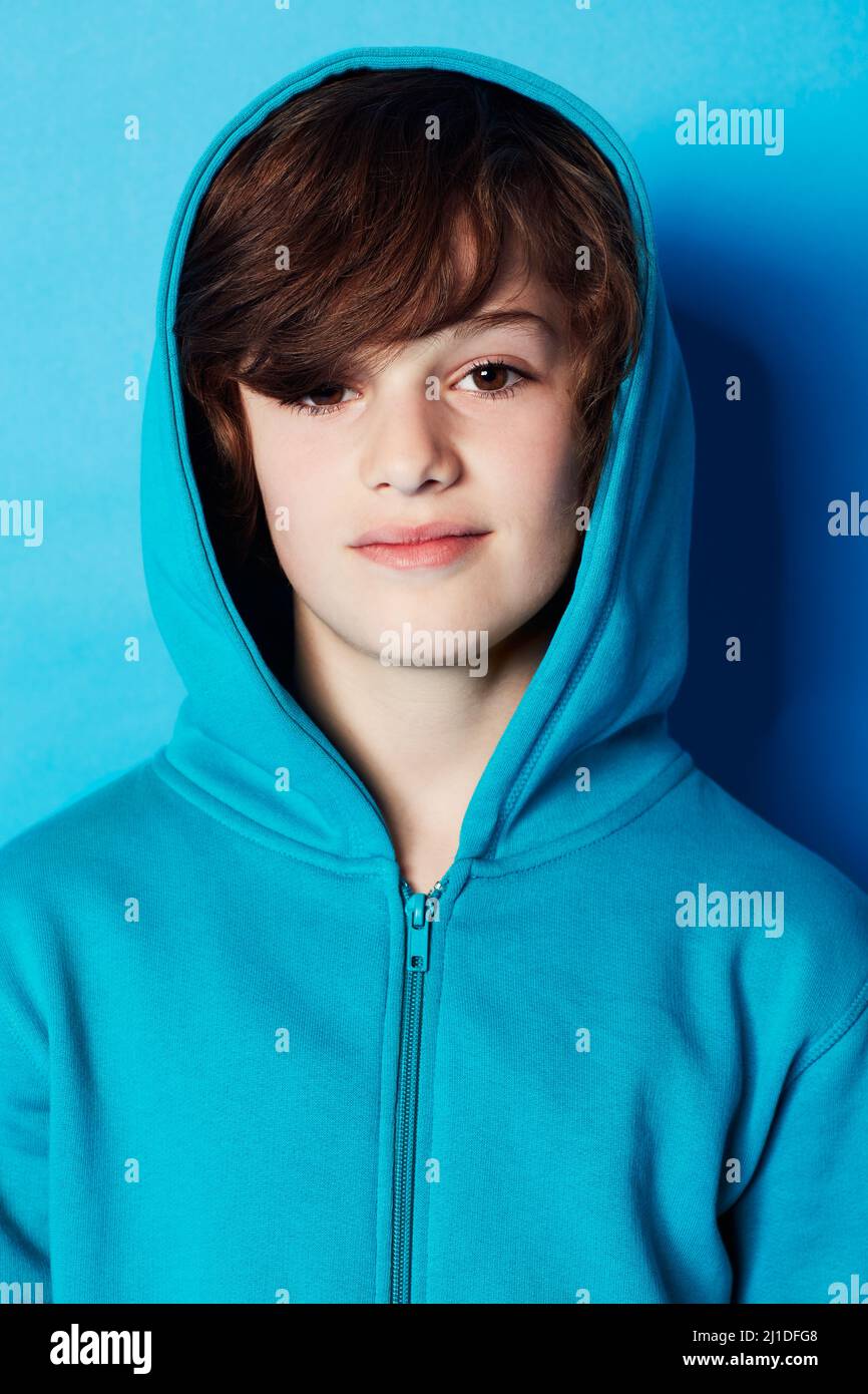 Casual and confident. Portrait of a young boy wearing a blue hoodie in the studio. Stock Photo