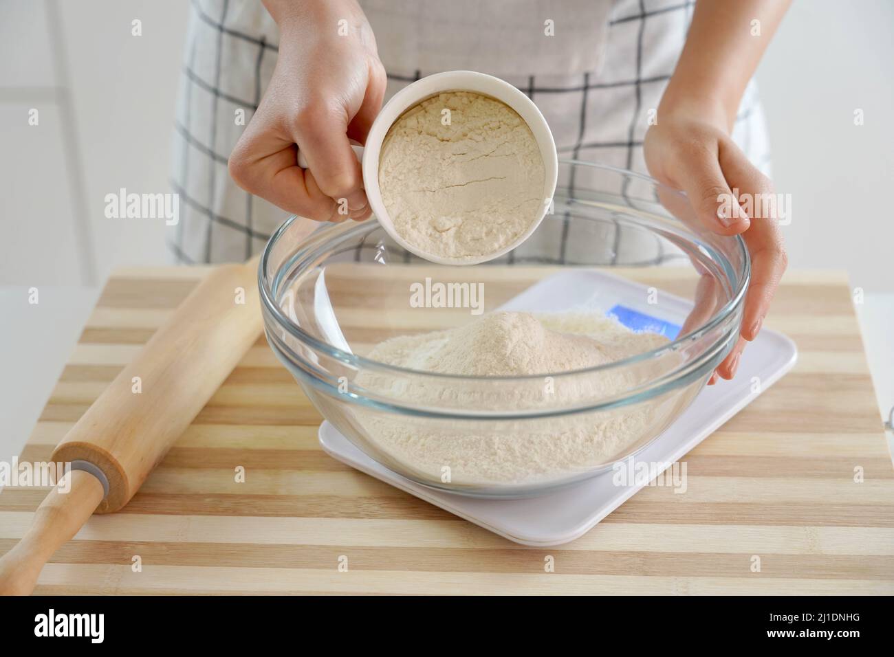 Closeup woman weigh the flour on the scales. Increasing price of wheat