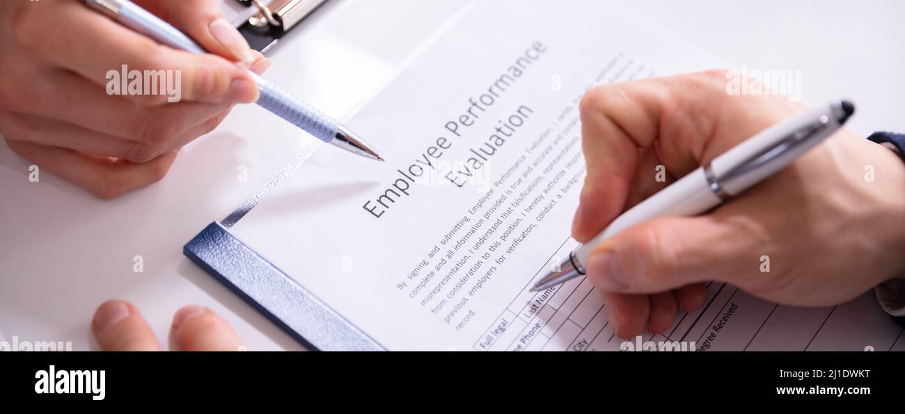 Close-up Of A Person Filling Performance Evaluation Form Of Employee ...