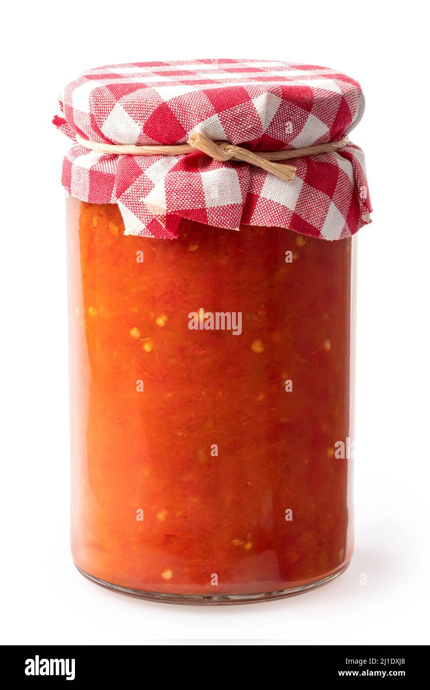 Ajvar in a closed glass jar isolated on white. Checkered fabric with a string. Stock Photo