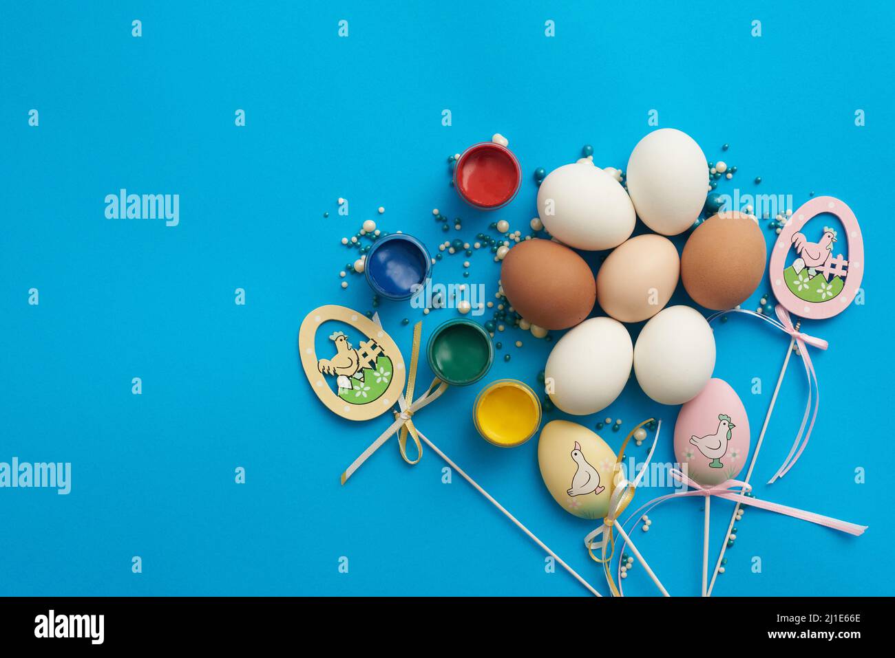 Design template for easter with eggs and paints on a blue background Stock Photo